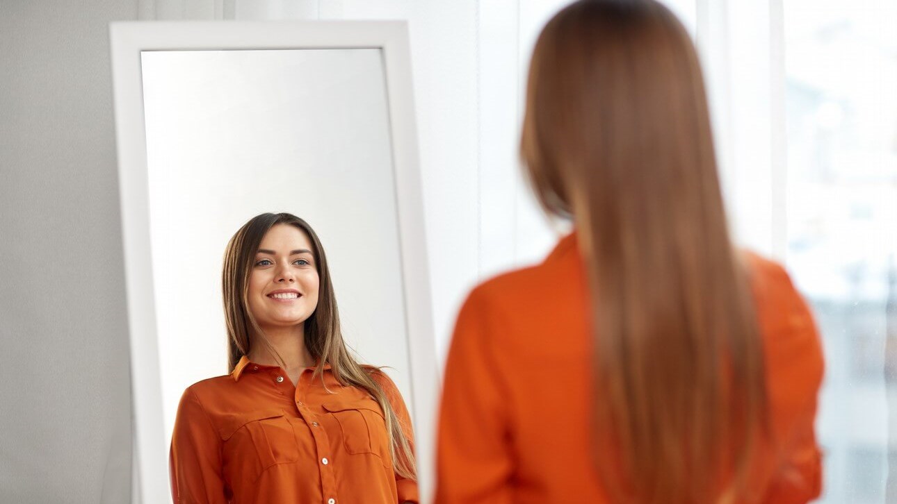 happy woman looking at mirror
